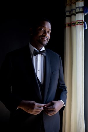 Groom attire - black tuxedo - Photo: Hollywood Pro Weddings