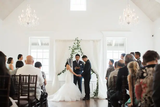 White wedding ceremony decor with greenery - Brooke Images