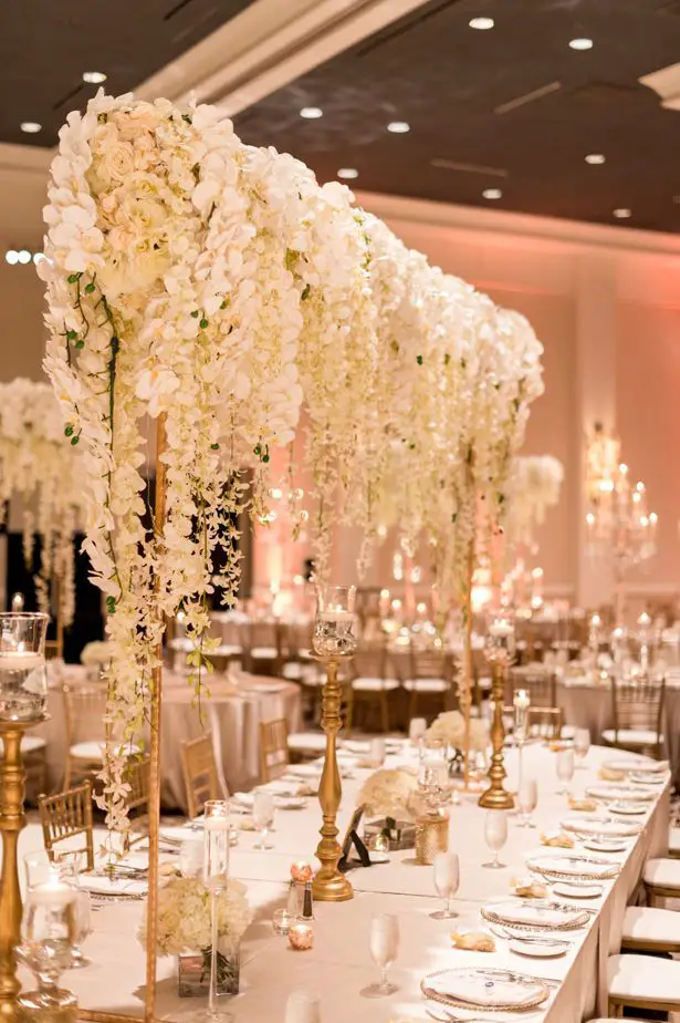 Hanging flower tall wedding centerpiece with white orchids and wisteria - Photographer: Julia Franzosa