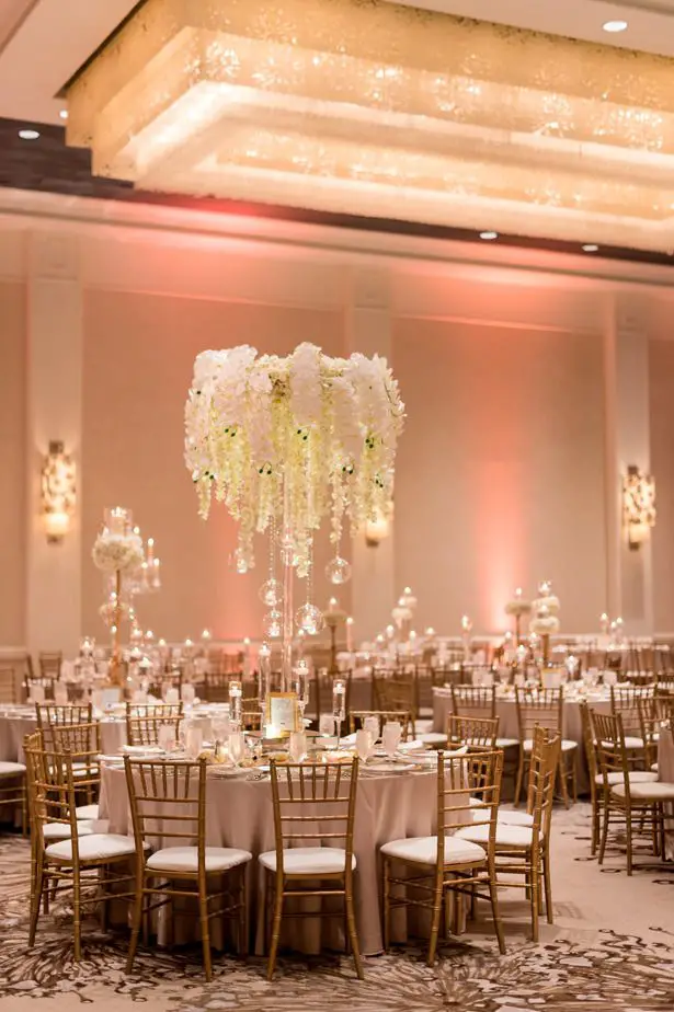 Hanging flower tall wedding centerpiece with white orchids and wisteria - Photographer: Julia Franzosa
