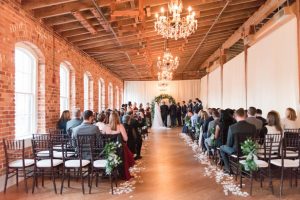 Indoor wedding ceremony decor with greenery arch - Photography by Marirosa