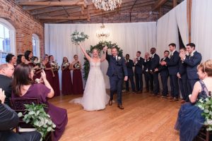 Indoor wedding ceremony decor with greenery arch - Photography by Marirosa