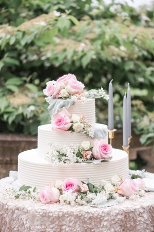 White buttercream wedding cake with fresh flowers and pink roses - Lynne Reznick Photography