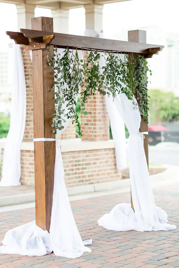 wood wedding arch with greenery - Luke & Ashley Photography