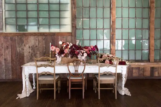 Long wedding tablescape with burgundy centerpieces - Photography: Szu Designs, Inc