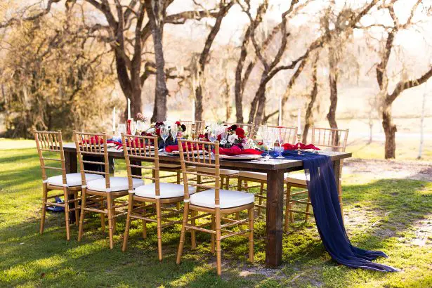 Burgundy and navy blue long wedding tablescape and gold chairs - Holley Elizabeth Photography