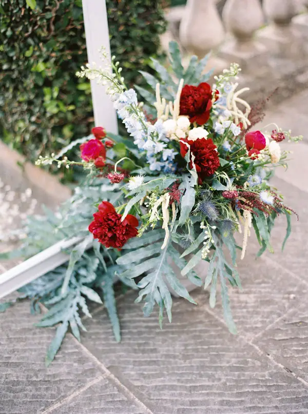 Red, blue and greenery wedding ceremony flowersn - Photography: The cablookfotolab