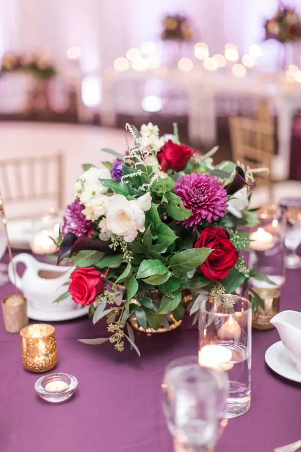 Low wedding centerpiece with colorful flowers on a purple linen - Photography: The Hendricks 