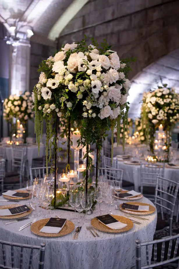 Tall wedding centerpiece with white flowers and greenery- Rafal Ostrowski Photography