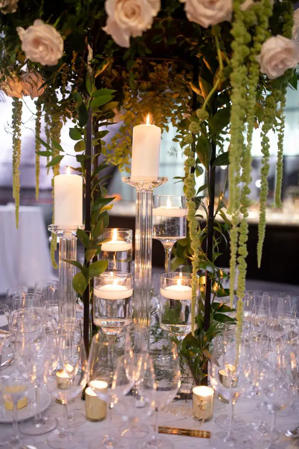 Tall wedding centerpiece with white flowers, candlelight and greenery - Rafal Ostrowski Photography