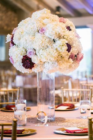 Flower centerpieces in white and burgundy for wedding reception A Glamorous Wedding with Fireworks - Rachael Hall Photography