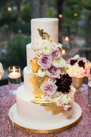 Glam gold and white wedding cake with flowers A Glamorous Wedding with Fireworks - Rachael Hall Photography