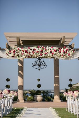 Stunning ceremony pergola with pink and white flowers A Glamorous Wedding with Fireworks - Rachael Hall Photography