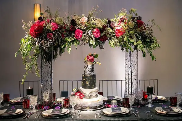 Bold and Glamorous wedding cake table with tall flowers and black and gold wedding cake - Little Honey Photography