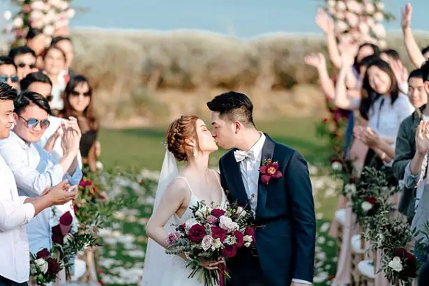 Bride and groom kidding at the end of the aisle - Madiow Photography