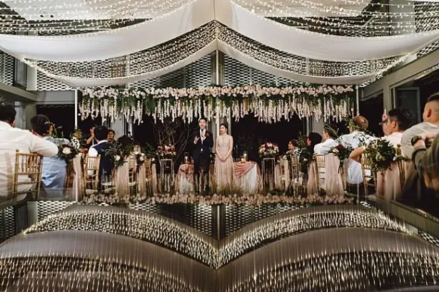 Epic hanging floral installation with string lights - Madiow Photography