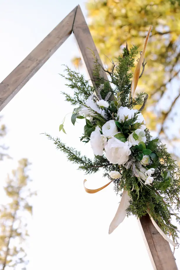 Boho wedding arbor with white flowers and greenery - Photo: Tiffany Hudson Films