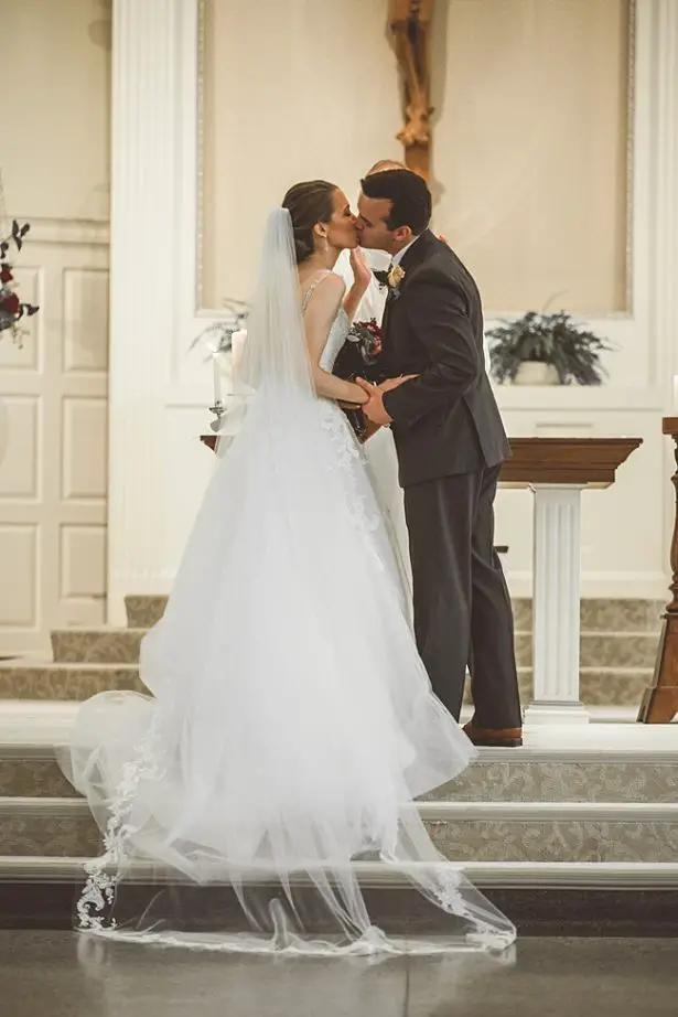Bride and groom first kiss photo in church ceremony - Aileen Elizabeth Photography