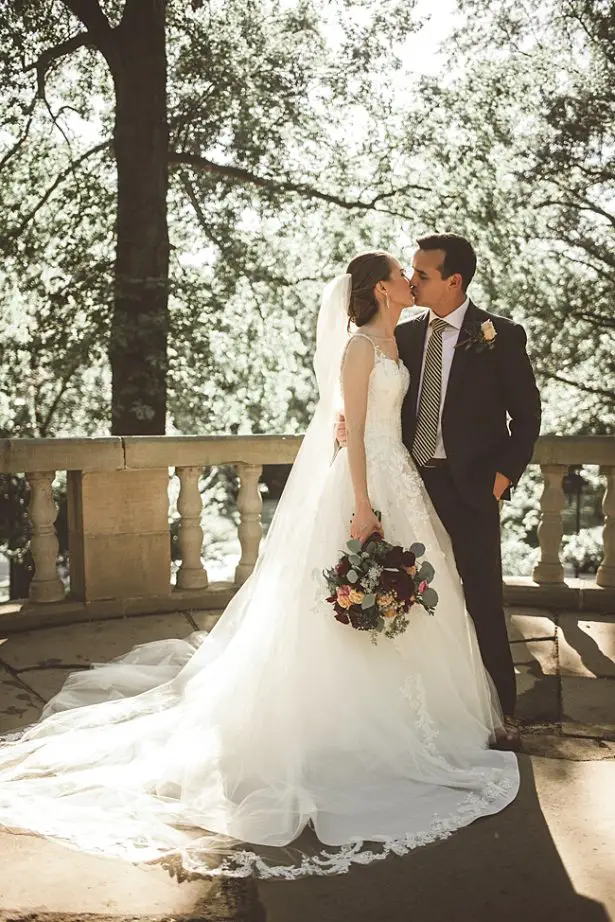 Bride and groom kissing with lace wedding dress and grey groom suit - Aileen Elizabeth Photography