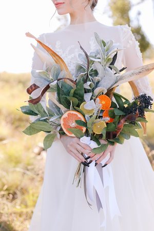 Citrus wedding bouquet and high neck lace wedding dress - Photo: Tiffany Hudson Films
