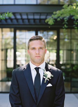 Classic black groom suit with black tie and white boutonnière - O’Malley Photography