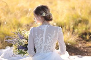 Elegant bridal updo and floral wedding dress with long sleeves - Photo: Tiffany Hudson Films