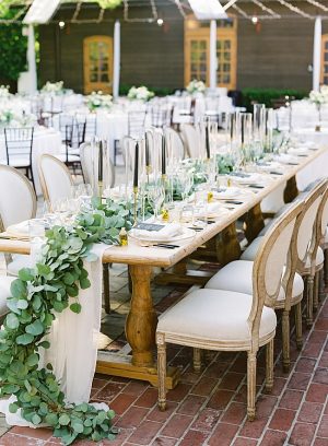Elegant wedding reception head table decor with greenery and black candles sticks- O’Malley Photography