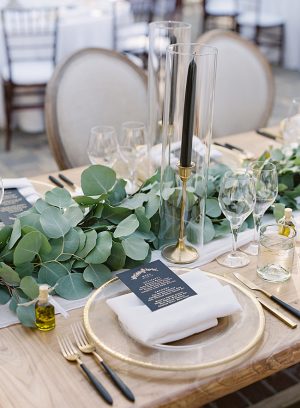 Gold table setting with black accents and greenery for wedding reception head table- O’Malley Photography