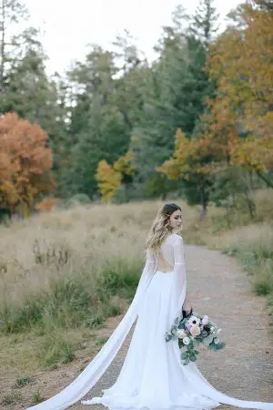 Romantic bridal portrait of bring in long sleeved wedding dress with an open back - Photo: Tiffany Hudson Films