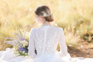 Romantic long sleeve wedding dress with flowers and buttons up the back - Photo: Tiffany Hudson Films