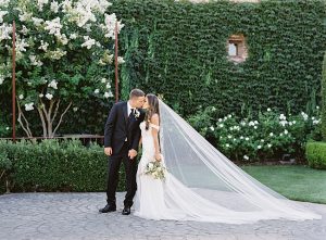 Romantic shot of bride and groom on their wedding day with cathedral length veil- O’Malley Photography