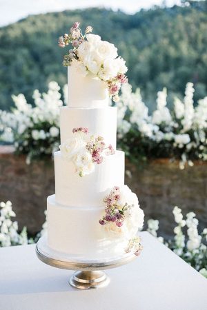 All white wedding cake with mauve and white flowers - Purewhite Photography