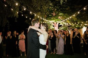 Bride and groom first dance under string lights in outdoor wedding reception - Purewhite Photography