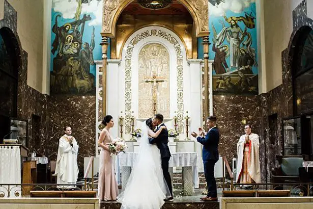 Cathedral wedding photo of bride and groom first kiss - Bluespark Photography