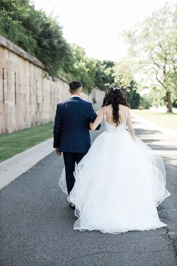 Country Club Wedding photo of bride and groom walking with bride in a ball gown - Bluespark Photography