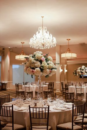 Country Club Wedding reception with tall floral centerpieces and chandelier - Photography: NST Pictures