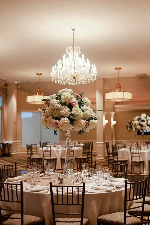 Country Club Wedding reception with tall floral centerpieces and chandelier - Bluespark Photography