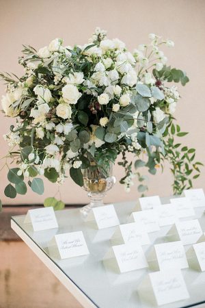 Elegant all white seating chart for wedding and white floral centerpiece with hanging greenery - Purewhite Photography