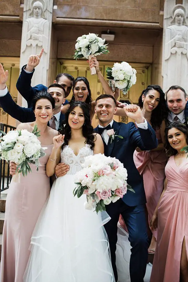 Fun photo of bride and groom celebrating with their bridal party - Bluespark Photography