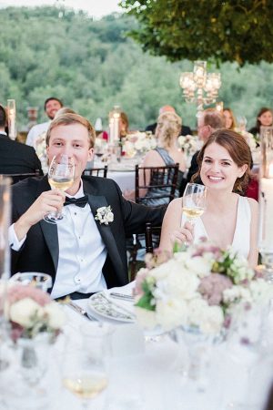 Outdoor wedding reception shot of bride and groom laughing during toasts - Purewhite Photography