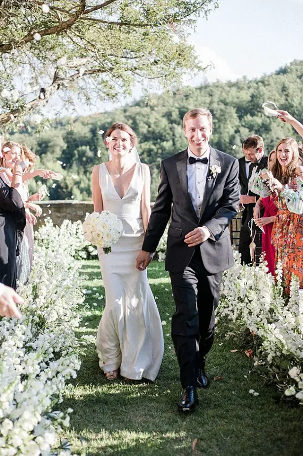 Photo of bride and groom recessional with petal toss - Purewhite Photography