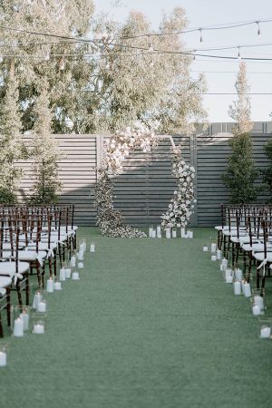 Unique shaped wedding-ceremony arbor with white flowers- Foolishly Rushing In Photography