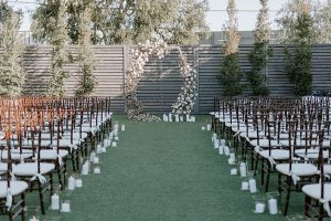 Unique shaped wedding-ceremony arbor with white flowers- Foolishly Rushing In Photography