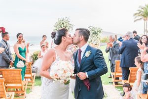 Beach wedding photo of bride and groom kissing down the aisle - Photography: JBJ Pictures