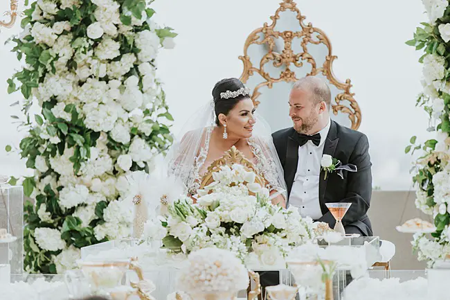 White and Gold Opulent Wedding sweetheart table with bride and groom - Photo: Dmitry Shumanev Production