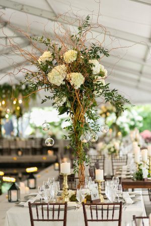 Tall wedding centerpiece with greenery and white flowers - Photography: Emilia Jane