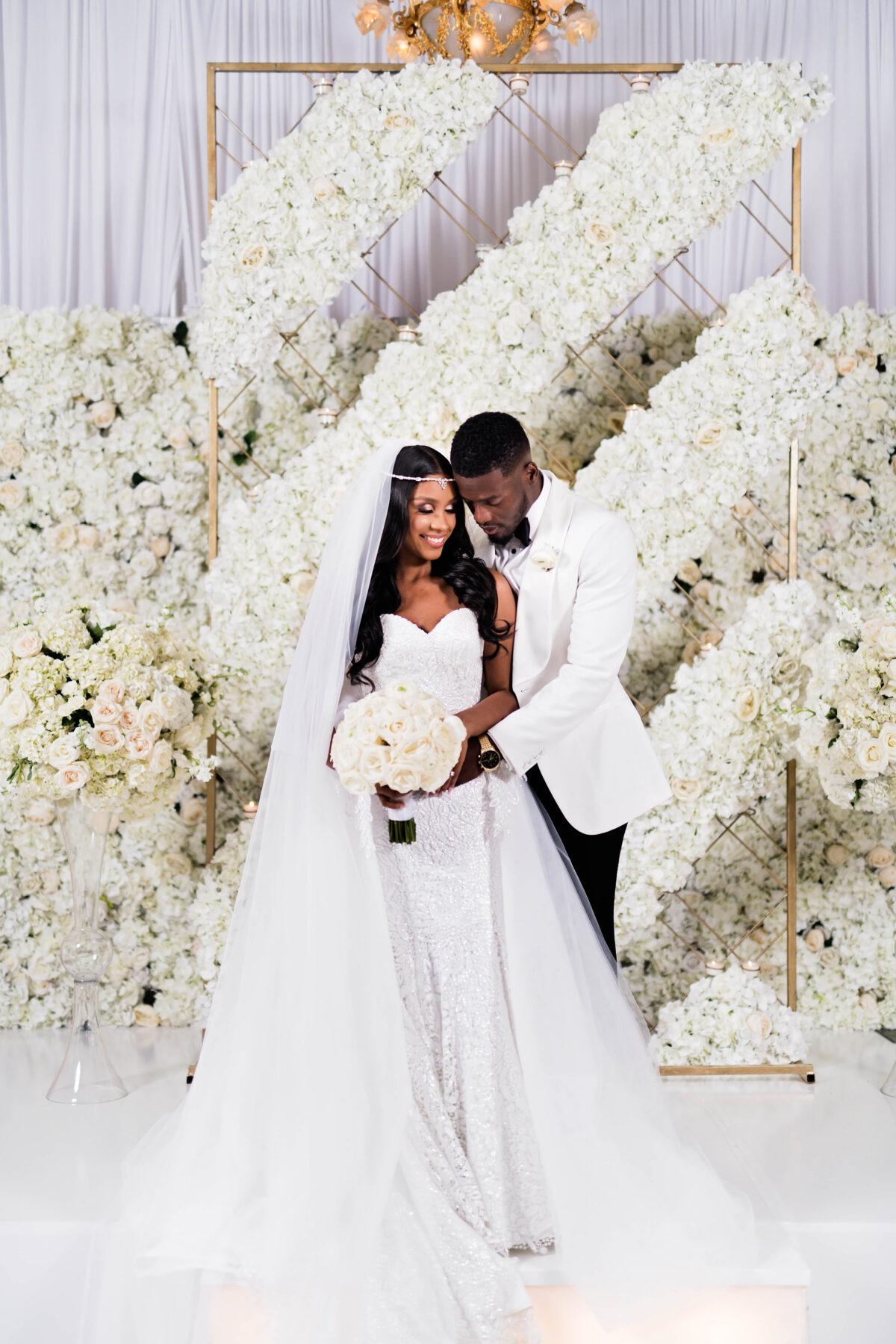 Luxury black bride and African American groom photo with floral wall - Photography: Pharris Photos