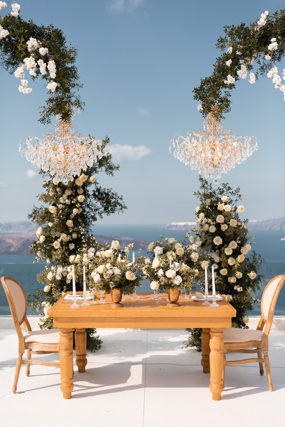 Luxury wedding sweetheart table decor with floral installations and chandeliers - Eva Rendl Photography